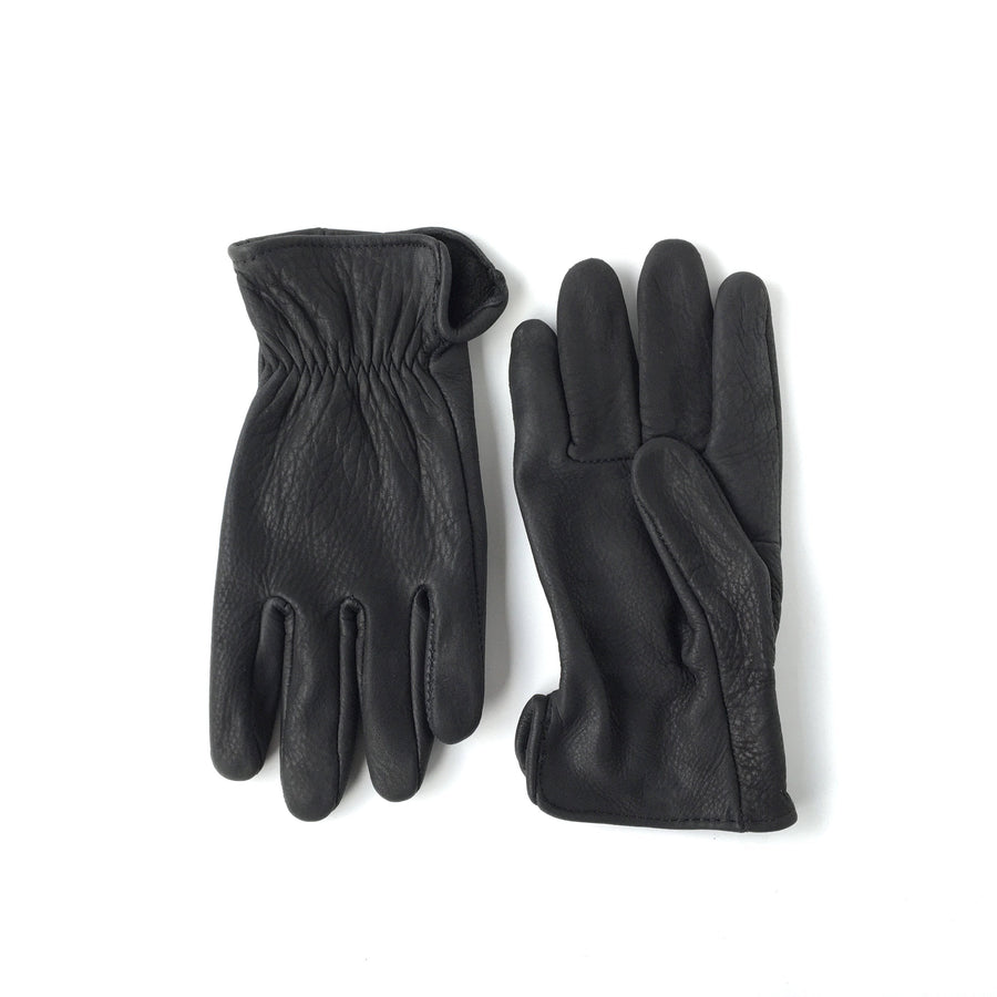 Pair of black gloves on a wooden surface